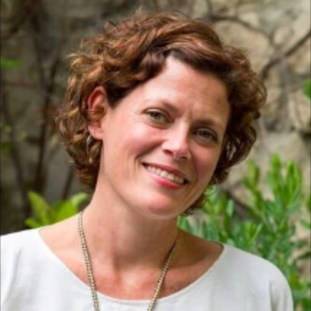 Portrait of Morag Makey, therapist, outdoors with greenery.